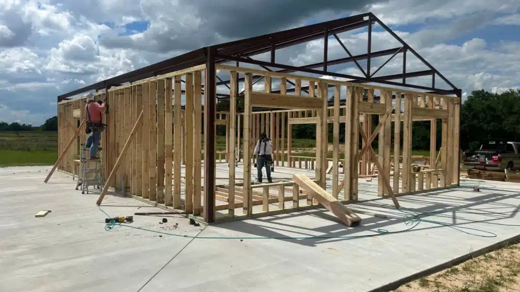 Construction site where builders are present and working on the foundations of a barndominium in Texas