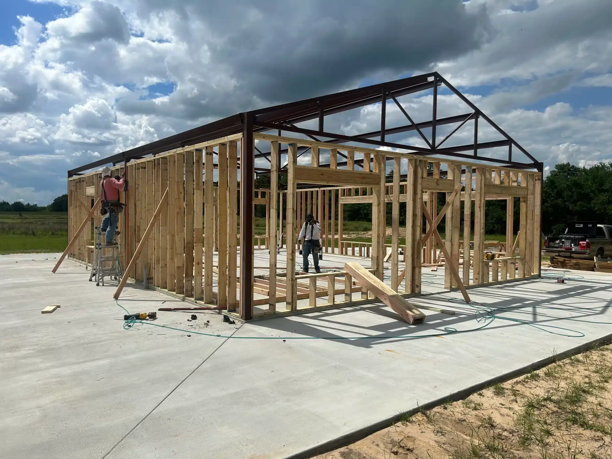 Barndominium frame on a new slab foundation on a tree-lined lot in East Texas